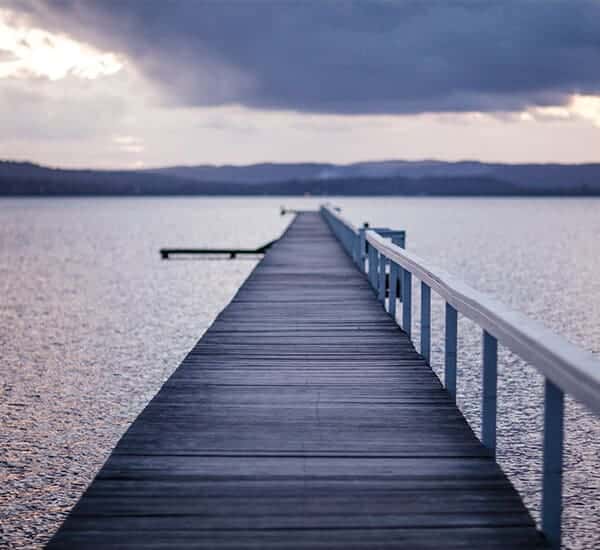 A shot of a wooden bridge across a river
